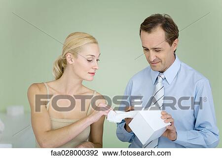 Couple standing together, man holding tissue box, woman taking tissue View Large Photo Image Stock Image - Couple standing together, man holding tissue box, woman taking tissue. Fotosearch