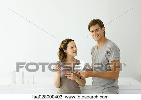 Couple standing together, woman holding baby bottle, man holding milk cartons and looking at camera View Large Photo Image Stock Image - Couple standing together, woman holding baby bottle, man holding milk cartons and looking at camera. Fotosearch