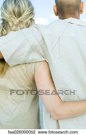 Couple standing with arms around each other, cropped rear view View Large Photo Image Stock Image - Couple standing with arms around each other, cropped rear view. Fotosearch