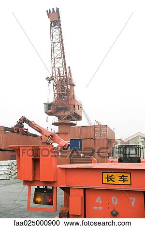 Stock Image - Cranes and cargo containers in shipyard. Fotosearch