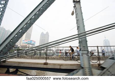 Cyclists and pedestrians on footbridge, cityscape in background View Large Photo Image Stock Photo - Cyclists and pedestrians on footbridge, cityscape in background. Fotosearch
