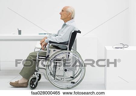 Elderly man sitting in wheelchair in doctor's office, side view View Large Photo Image Stock Photography - Elderly man sitting in wheelchair in doctor's office, side view. Fotosearch