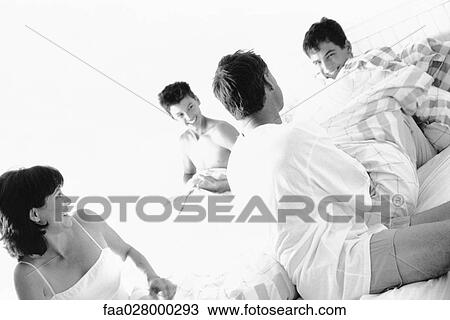 Family dressed in pajamas, sitting on bed, smiling at laughing View Large Photo Image Stock Image - Family dressed in pajamas, sitting on bed, smiling at laughing. Fotosearch