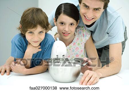 Father and two children baking together, all smiling at camera View Large Photo Image Stock Photo - Father and two children baking together, all smiling at camera. Fotosearch