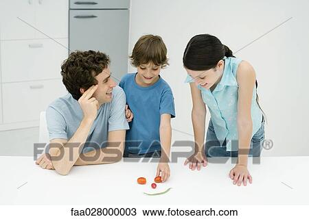 Father and two children in kitchen, making smiley face out of vegetables View Large Photo Image Stock Image - Father and two children in kitchen, making smiley face out of vegetables. Fotosearch
