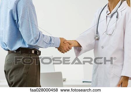 Female doctor shaking man's hand, side view, cropped View Large Photo Image Stock Photo - Female doctor shaking man's hand, side view, cropped. Fotosearch