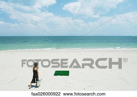 Girl at the beach walking toward patch of artificial turf, carrying watering can, rear view View Large Photo Image Stock Image - Girl at the beach walking toward patch of artificial turf, carrying watering can, rear view. Fotosearch