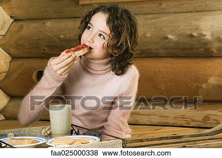 Girl having snack, looking away View Large Photo Image Stock Photo - Girl having snack, looking away. Fotosearch