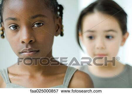 Girl looking at camera, friend in background View Large Photo Image Stock Photo - Girl looking at camera, friend in background. Fotosearch