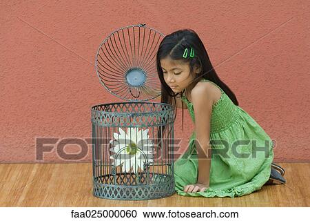 Girl opening up birdcage, looking at flower View Large Photo Image Stock Image - Girl opening up birdcage, looking at flower. Fotosearch