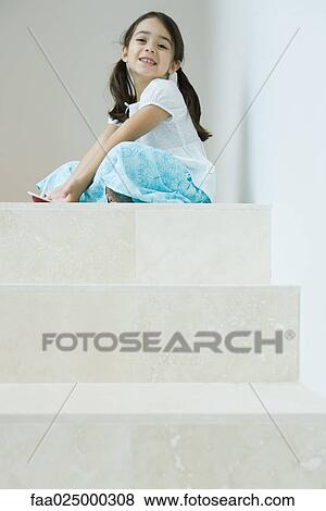 Girl sitting on steps playing with top, smiling at camera, low angle view View Large Photo Image Stock Photo - Girl sitting on steps playing with top, smiling at camera, low angle view. Fotosearch