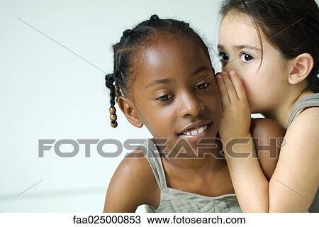 Girl whispering in friend's ear, close-up View Large Photo Image Stock Image - Girl whispering in friend's ear, close-up. Fotosearch
