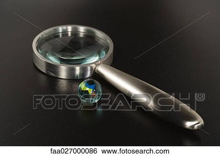 Glass marble and magnifying glass, close-up View Large Photo Image Stock Photograph - Glass marble and magnifying glass, close-up. Fotosearch