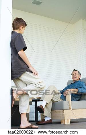 Grandfather and grandson face to face on porch, man sitting, boy standing View Large Photo Image Stock Photo - Grandfather and grandson face to face on porch, man sitting, boy standing. Fotosearch