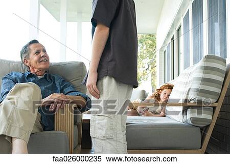 Grandfather and grandson talking on porch, little girl in the background looking at camera View Large Photo Image Stock Photography - Grandfather and grandson talking on porch, little girl in the background looking at camera. Fotosearch
