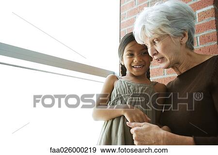 Grandmother and granddaughter cheek to cheek, holding hands, looking at each other View Large Photo Image Stock Photo - Grandmother and granddaughter cheek to cheek, holding hands, looking at each other. Fotosearch