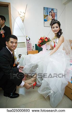 Groom putting shoe on bride's foot in bedroom, both smiling at camera, full length View Large Photo Image Stock Image - Groom putting shoe on bride's foot in bedroom, both smiling at camera, full length. Fotosearch