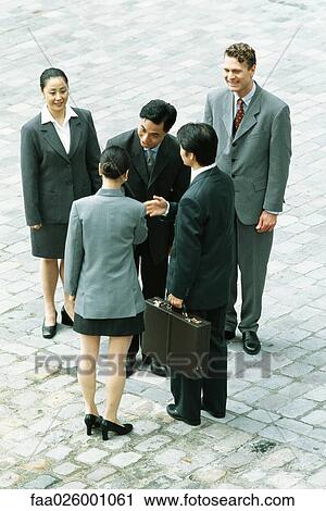 Group of professionals standing together, man and woman shaking hands, high angle view View Large Photo Image Stock Image - Group of professionals standing together, man and woman shaking hands, high angle view. Fotosearch