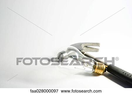 Hammer resting beside light bulb, close-up View Large Photo Image Stock Photo - Hammer resting beside light bulb, close-up. Fotosearch