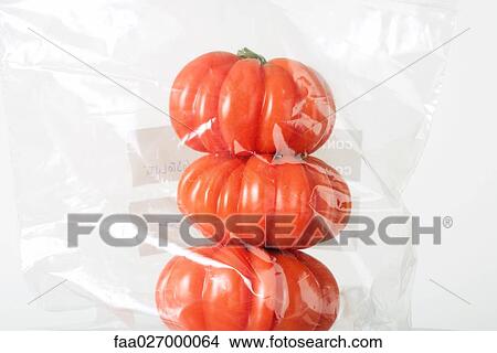 Heirloom tomatoes stacked in plastic bag, close-up View Large Photo Image Picture - Heirloom tomatoes stacked in plastic bag, close-up. Fotosearch