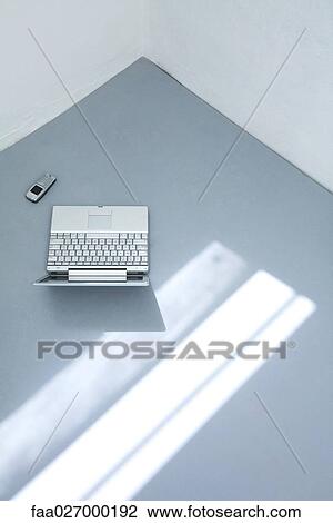 Laptop computer and cell phone on the ground, high angle view View Large Photo Image Stock Image - Laptop computer and cell phone on the ground, high angle view. Fotosearch