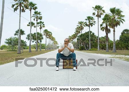 leaning on elbow, sitting, suitcase, road, traveler, hitchhiker View Large Photo Image Stock Image - leaning on elbow, sitting, suitcase, road, traveler, hitchhiker. Fotosearch