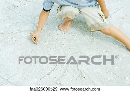 Little boy at the beach drawing in sand with stick, cropped view View Large Photo Image Stock Photo - Little boy at the beach drawing in sand with stick, cropped view. Fotosearch