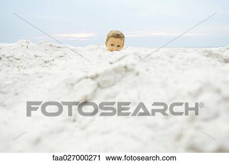 Little boy at the beach, peeking over sand, smiling View Large Photo Image Stock Image - Little boy at the beach, peeking over sand, smiling. Fotosearch