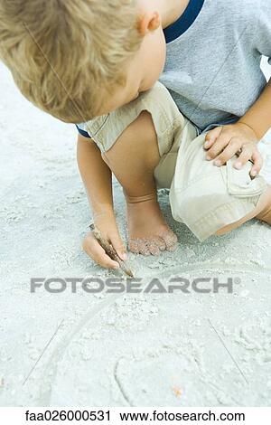 Little boy crouching at the beach, drawing in sand with stick, head resting on knee View Large Photo Image Stock Image - Little boy crouching at the beach, drawing in sand with stick, head resting on knee. Fotosearch