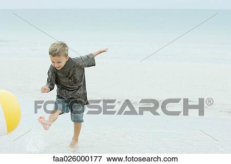 Little boy kicking beach ball at the beach View Large Photo Image Stock Photo - Little boy kicking beach ball at the beach. Fotosearch