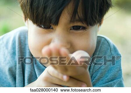 Little boy looking down at cupped hand, close-up View Large Photo Image Stock Image - Little boy looking down at cupped hand, close-up. Fotosearch