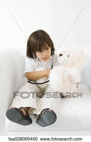 Little boy playing doctor with stuffed toy, using stethoscope View Large Photo Image Stock Image - Little boy playing doctor with stuffed toy, using stethoscope. Fotosearch