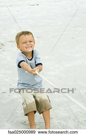 Little boy pulling on rope, making face, on beach View Large Photo Image Stock Photo - Little boy pulling on rope, making face, on beach. Fotosearch