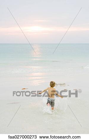 Little boy running at the beach, arms out, rear view View Large Photo Image Stock Image - Little boy running at the beach, arms out, rear view. Fotosearch