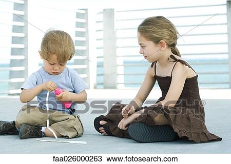 Little boy sitting on the ground inflating balloon with air pump, older sister watching View Large Photo Image Stock Image - Little boy sitting on the ground inflating balloon with air pump, older sister watching. Fotosearch