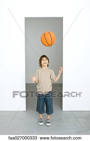 Little boy throwing basketball in the air, looking up, smiling View Large Photo Image Stock Image - Little boy throwing basketball in the air, looking up, smiling. Fotosearch