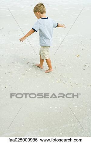 Little boy walking on beach with arms out, full length View Large Photo Image Stock Photograph - Little boy walking on beach with arms out, full length. Fotosearch