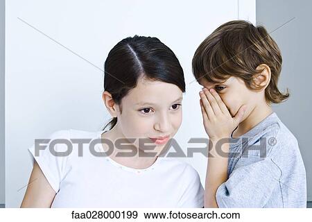 Little boy whispering in sister's ear, girl smiling View Large Photo Image Stock Photo - Little boy whispering in sister's ear, girl smiling. Fotosearch