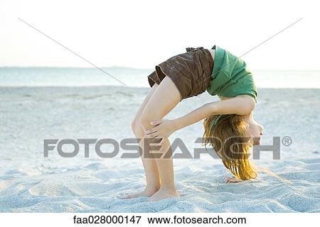 Little girl doing backbend at the beach, side view View Large Photo Image Stock Photo - Little girl doing backbend at the beach, side view. Fotosearch