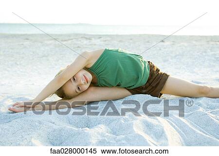 Little girl doing split at the beach, leaning over, arms raised, smiling at camera View Large Photo Image Stock Photography - Little girl doing split at the beach, leaning over, arms raised, smiling at camera. Fotosearch