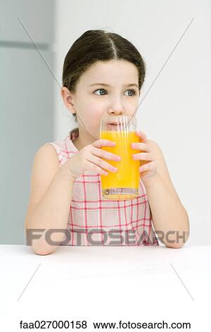 Little girl drinking orange juice, looking away, close-up View Large Photo Image Stock Photo - Little girl drinking orange juice, looking away, close-up. Fotosearch