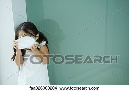 Little girl hiding face behind coin purse View Large Photo Image Picture - Little girl hiding face behind coin purse. Fotosearch