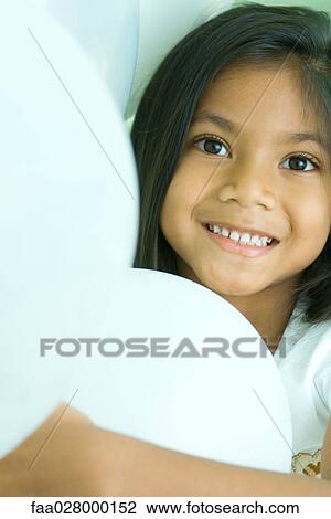 Little girl holding balloons in arms, smiling at camera, portrait View Large Photo Image Stock Image - Little girl holding balloons in arms, smiling at camera, portrait. Fotosearch