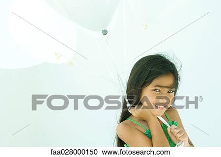 Little girl holding balloons, smiling at camera, portrait View Large Photo Image Stock Image - Little girl holding balloons, smiling at camera, portrait. Fotosearch