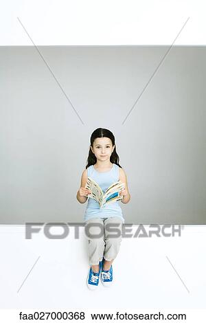 Little girl holding book, looking at camera, full length View Large Photo Image Stock Photo - Little girl holding book, looking at camera, full length. Fotosearch