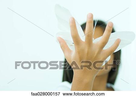 Little girl holding butterfly, hand in front of face, low angle view View Large Photo Image Stock Photo - Little girl holding butterfly, hand in front of face, low angle view. Fotosearch