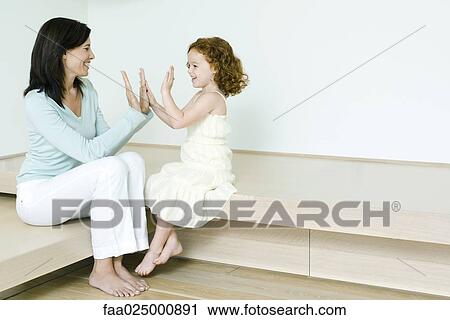 Little girl playing clapping game with mother View Large Photo Image Stock Image - Little girl playing clapping game with mother. Fotosearch
