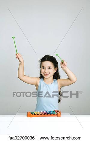 Little girl playing xylophone, arms raised, smiling View Large Photo Image Stock Image - Little girl playing xylophone, arms raised, smiling. Fotosearch
