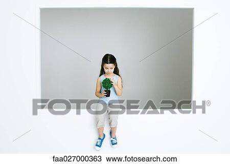Little girl sitting, holding potted plant, looking down View Large Photo Image Stock Image - Little girl sitting, holding potted plant, looking down. Fotosearch