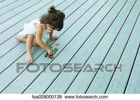 Little girl sitting on deck, playing with plastic toys, high angle view View Large Photo Image Stock Photo - Little girl sitting on deck, playing with plastic toys, high angle view. Fotosearch
